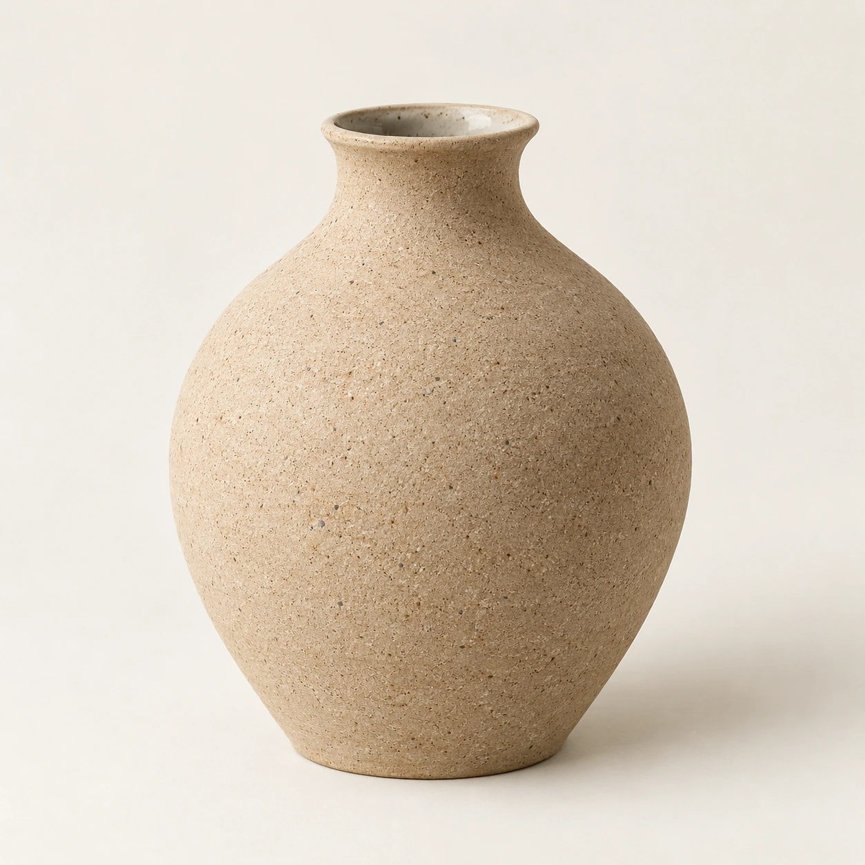 Ceramic vessel in sand, an illustrative concept product on a warm neutral background