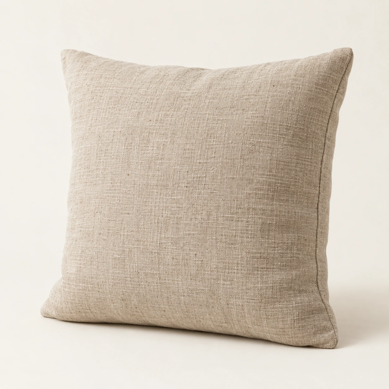 Linen cushion in oat, an illustrative concept product on a warm neutral background