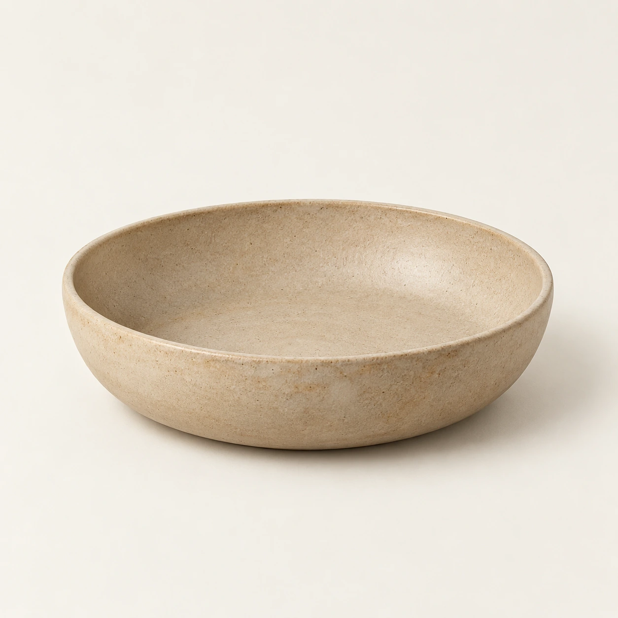 Stoneware bowl in sand, an illustrative concept product on a warm neutral background
